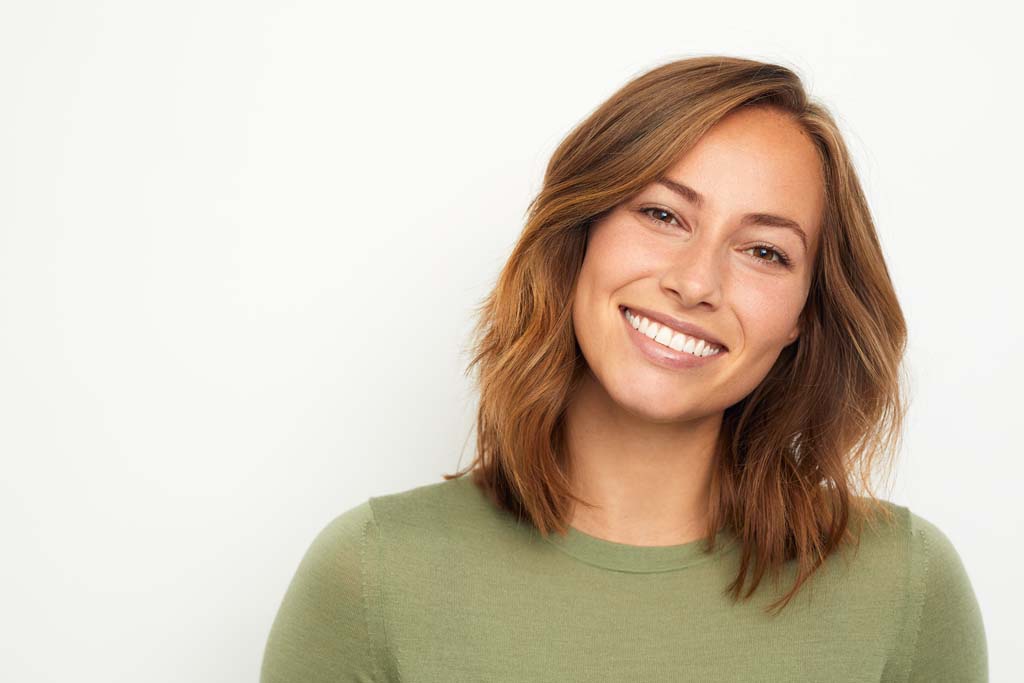 portrait of a young happy woman smiling on white background